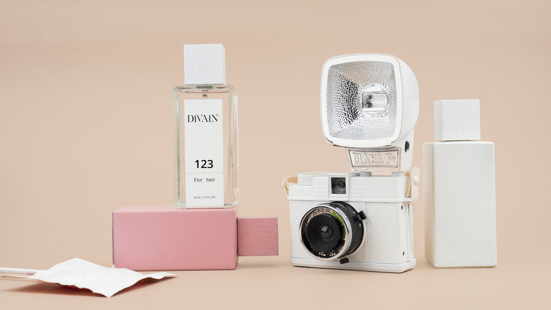 Perfumes dupes divain next to a camera 
