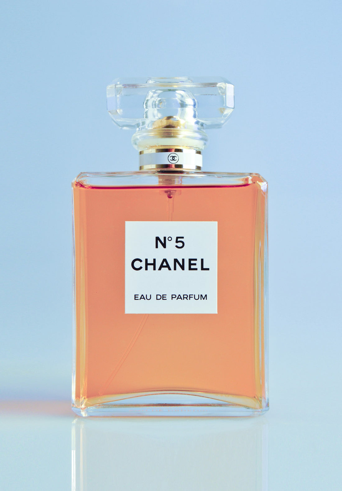 Amber-colored perfume bottle among autumn leaves